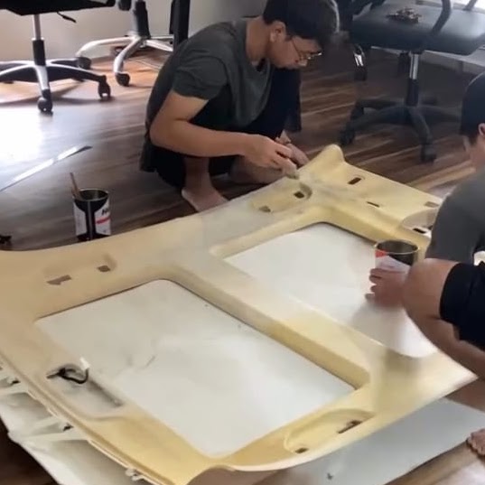 Tim sedang mengerjakan pelapisan plafon mobil